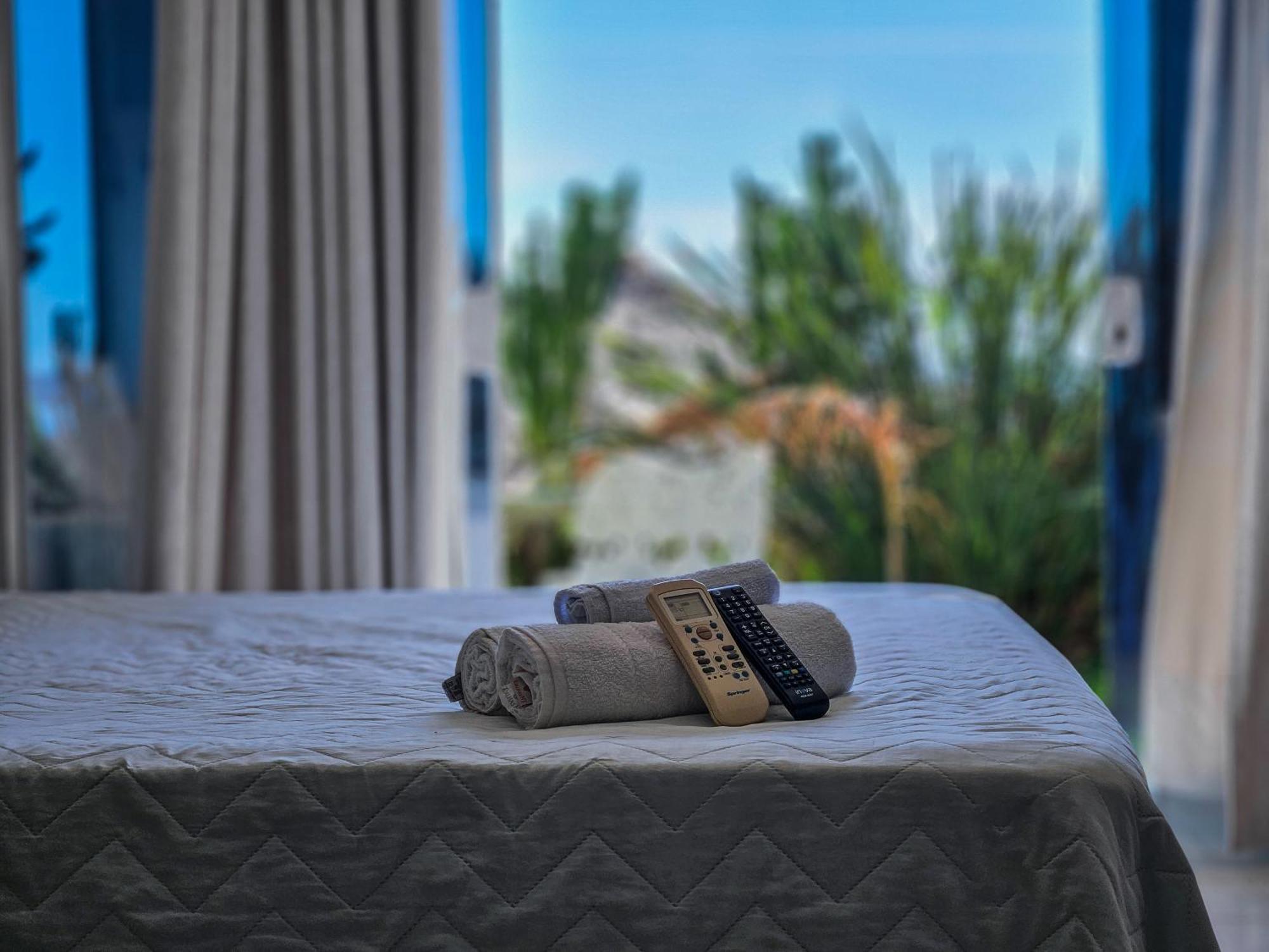Отель Bella Vista Ocean View Armacao dos Buzios Экстерьер фото A bed with a remote control and a towel